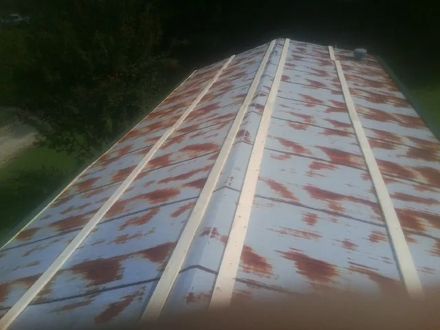 Rusted metal roof panels with new wood purlins before replacement — Storm Damage Roof Repair in Drakesboro by Roofing Brothers
