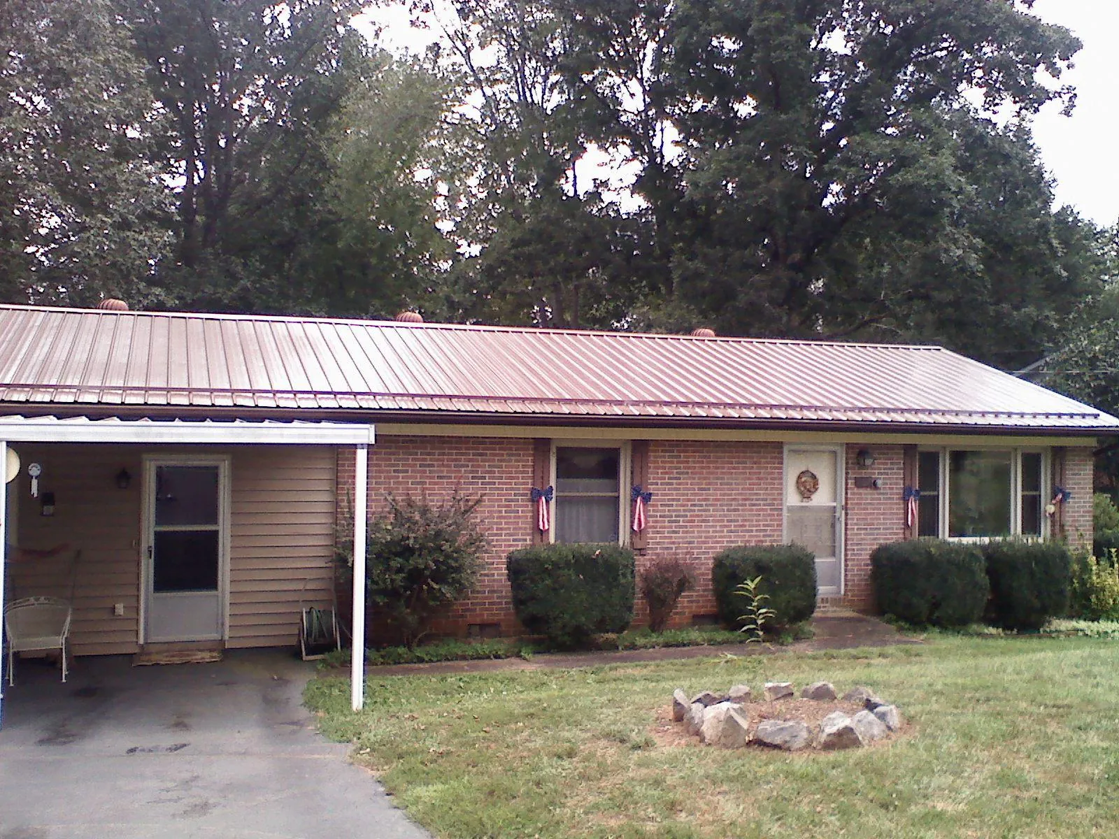Bronze metal roof and carport on a brick ranch home — Roof Repair work by our crew in Drakesboro